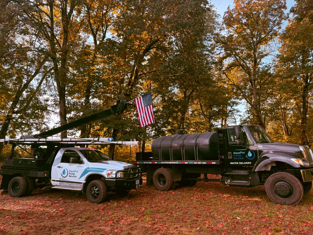 Two branded Aqua Pro Pump Service trucks parked side by side in Oregon